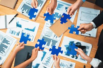 Multiethnic business people holding jigsaw pieces and merge them together as effective solution...