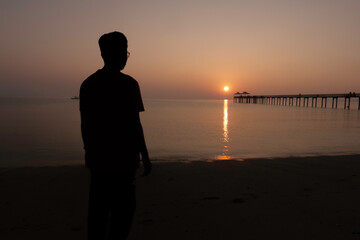Fototapeta premium silhouette of a person on the beach at sunset