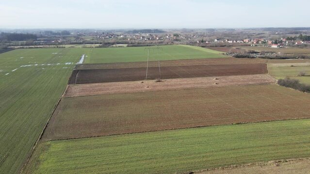 Drone flight above green agricultural fields with puddles in Ub, Serbia