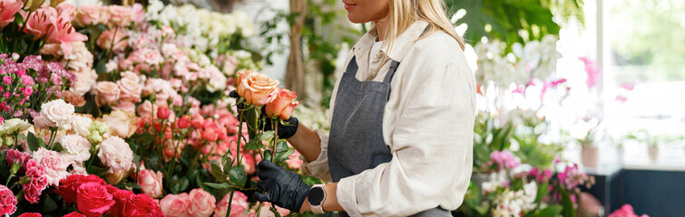Woman florist flower shop owner hold roses on floral background. High quality photo - obrazy, fototapety, plakaty