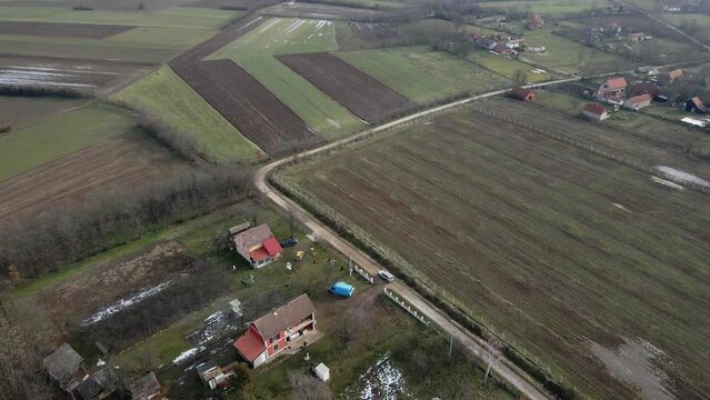 Aerial footage of small houses in cloutryside in cloudy weather in Ub, Serbia
