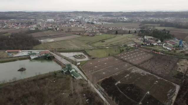 Drone flies above a lake and surrounding fields in Ub, Serbia