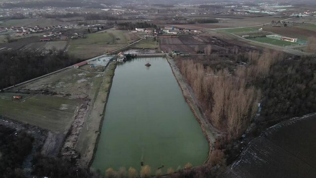 Drone flies towards lake in countryside in sunrise in Ub, Serbia
