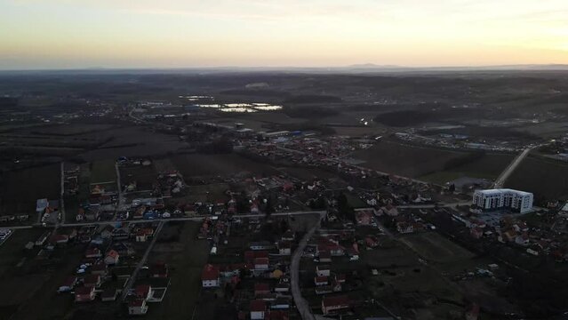 Drone captures the countryside lake near a village during sunset