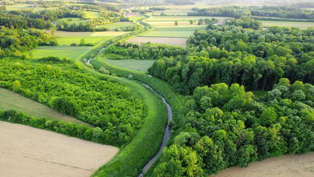 Drone flies around river Ub surrounded by greenery and agricultural fields in Serbia