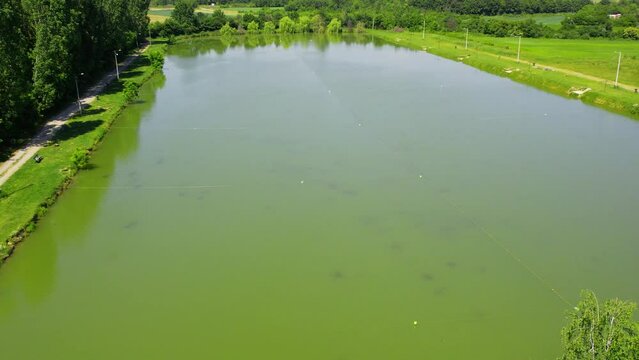 A calm lake surrounded by green lawn and bushes in Ub, Serbia in sunny day