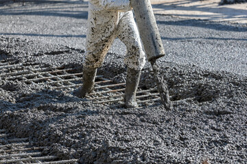 Construction worker is pouring and smoothing out concrete with ready-mix concrete (RMC). It is...