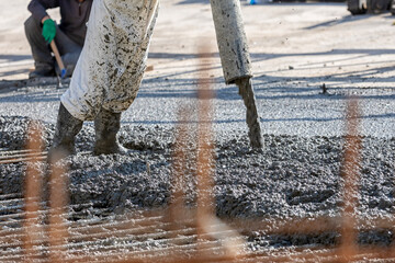 Construction worker is pouring and smoothing out concrete with ready-mix concrete (RMC). It is...
