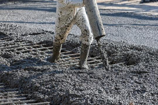 Construction worker is pouring and smoothing out concrete with ready-mix concrete (RMC). It is concrete that is manufactured in a batch plant, according to each specific job requirement.