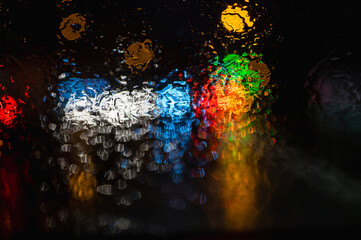 Water and rain drops on the glass, abstract view. night city bokeh