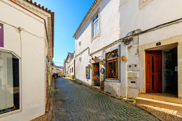 A picturesque tiled street of shops and sidewalk cafes in the historic old town center of seaside...