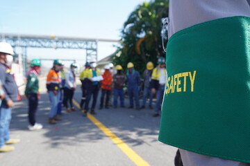 Green armband shows safety message in construction projects in industrial plant - obrazy, fototapety, plakaty