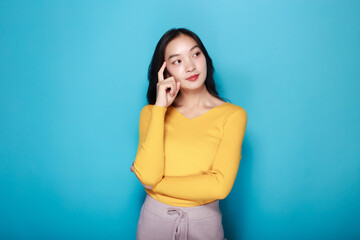 Portrait of a beautiful young woman in a light blue background, happy and smile, posting in stand position, Pretty girl makes a thoughtful expression.