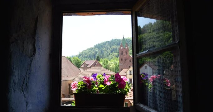 A cinematic view from a troglodyte house in Graufthal, Alsace, France, overlooking the church and forest, blending history with nature