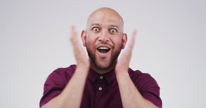 Omg, surprise and hands on face of man in studio with news, announcement or deal giveaway on grey background. Wow, emoji and portrait of male winner mind blown by competition, prize or lotto success