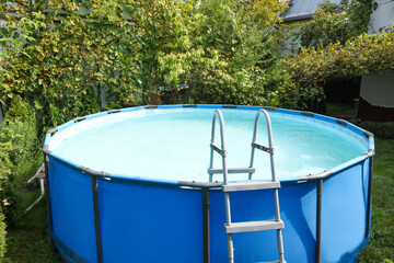 Above ground swimming pool in backyard on sunny day