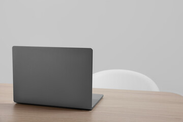 Stylish modern laptop on wooden table indoors. Space for text
