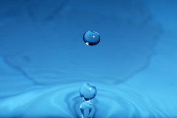 Splash of blue water with drop, macro view