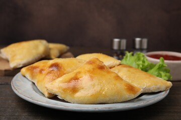 Delicious samosas and lettuce on wooden table