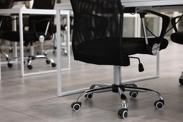 Comfortable office chairs and tables in meeting room, closeup