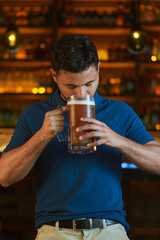 Hombre latino con una cerveza en un bar con colores calidos. con espacio para copy y diseños con expresiones 