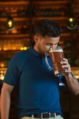 Hombre latino con una cerveza en un bar con colores calidos. con espacio para copy y diseños con expresiones 