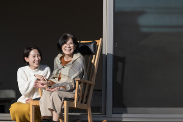 Autumn/Winter image of daughter and mother caring for the elderly Wide angle of parent and child looking up having a friendly conversation