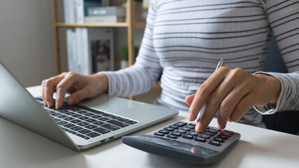 Financial research, government taxes and calculation tax return concept.Businessman using the laptop computer and calculator with virtual income tax online return icon form for payment.