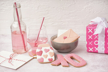 Composition with sweet cookies, glass of drink and gifts on light background. Valentine's Day celebration