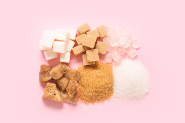 Different types of sugar on pink background