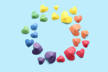 Frame made of colorful paper hearts on blue background. LGBT concept
