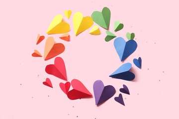 Frame made of colorful paper hearts on pink background. LGBT concept