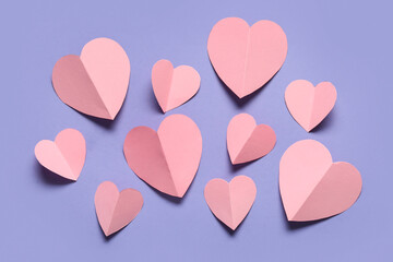 Composition with pink paper hearts on lilac background. Valentines Day celebration