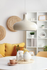 Dinning table with teapot and cup in room