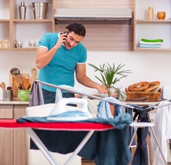 Young man husband doing clothing ironing at home