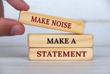 Make noise, make a statement text on wooden blocks. Business concept