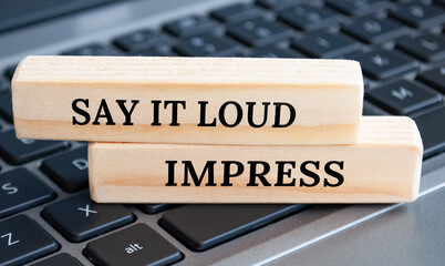 Say it loud and impress text on wooden blocks. Business concept