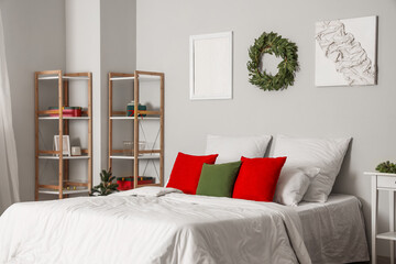 Interior of light bedroom with Christmas wreath and shelf units