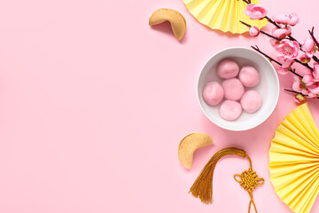 Bowl of tangyuan, fortune cookies, Chinese decor and sakura on pink background. Dongzhi Festival - obrazy, fototapety, plakaty