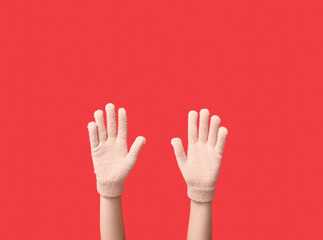 Hands in warm gloves on red background