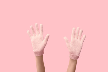 Hands in warm gloves on pink background