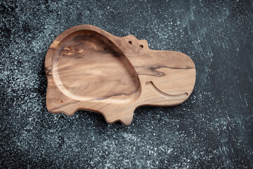 The children's plate in the shape of a hippopotamus is made of wood for serving snacks, fruits, nuts, cheeses, meat and original serving of main dishes. Accessories for a modern kitchen.