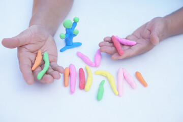 Close up man hands holds small colorful plasticine dough bars to make figures. Concept, alzheimer,...