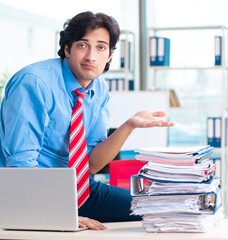Handsome businessman unhappy with excessive work in the office