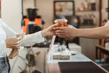Waitress giving coffee cup  to customer at coffee shop. SME business coffee shop concept.