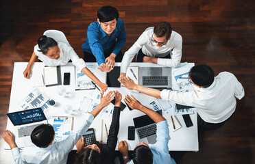 Fototapeta na wymiar Top view diverse office worker join hand together in office room symbolize business synergy and strong productive teamwork in workplace. Cooperation and unity between business employee. Prudent