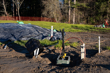 Freshly dug up ground and in progress installation of underground utilities on a new residential...