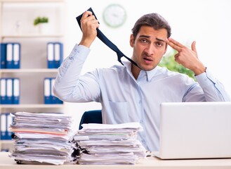 Obraz premium Young male employee unhappy with excessive work