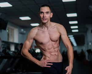 Fototapeta premium Shirtless man with sculpted body in the gym. 