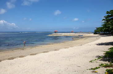 Sanur Beach, Sanur, Bali, Indonesia with breakwater and pavilion.